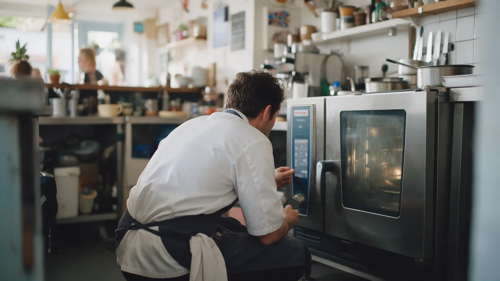 A chef checking a combi oven that has stopped heating